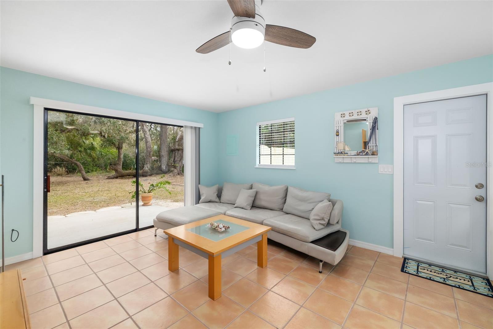 living room with ceiling fan and light tile patterned flooring