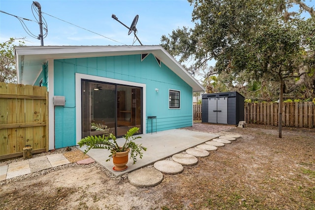 3200 Tobero Ln, Sarasota, FL 34235 - rear view of house featuring a fenced backyard, an outdoor structure, a patio area, and a storage unit