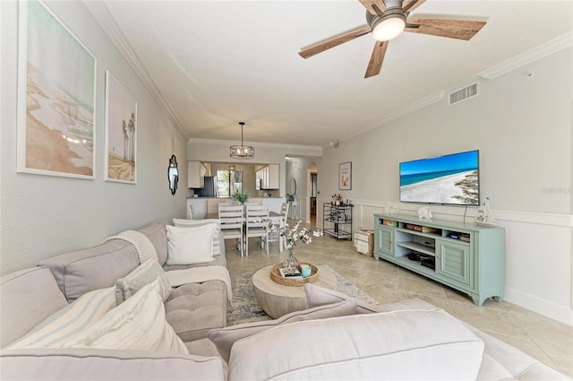 living room with light tile patterned floors, crown molding, and ceiling fan