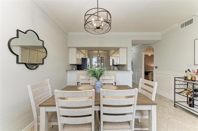 dining area with crown molding, light tile patterned flooring, and a chandelier