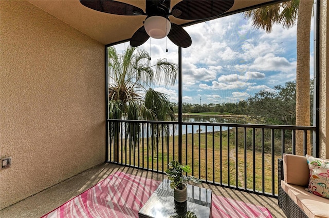 balcony featuring a water view and ceiling fan