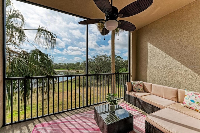 sunroom featuring a water view and ceiling fan