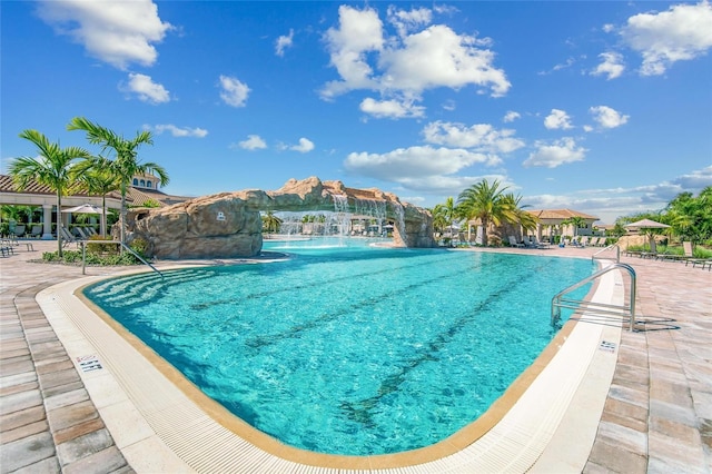 view of swimming pool with pool water feature and a patio