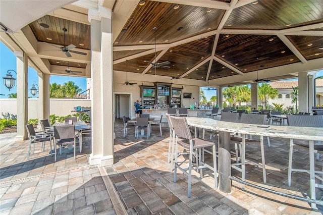 view of patio featuring a gazebo, ceiling fan, and a bar