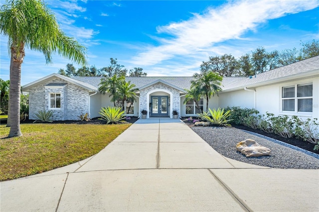 ranch-style house with french doors and a front yard