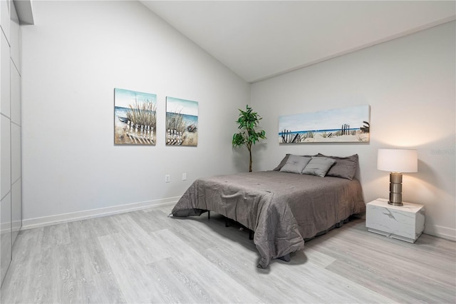 bedroom featuring vaulted ceiling and light wood-type flooring