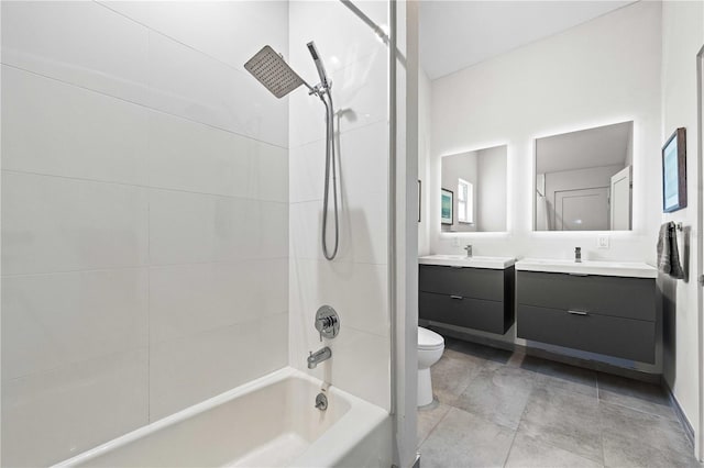 full bathroom featuring vanity, tiled shower / bath combo, and toilet