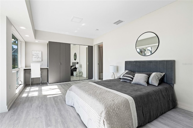 bedroom with light hardwood / wood-style floors and a closet