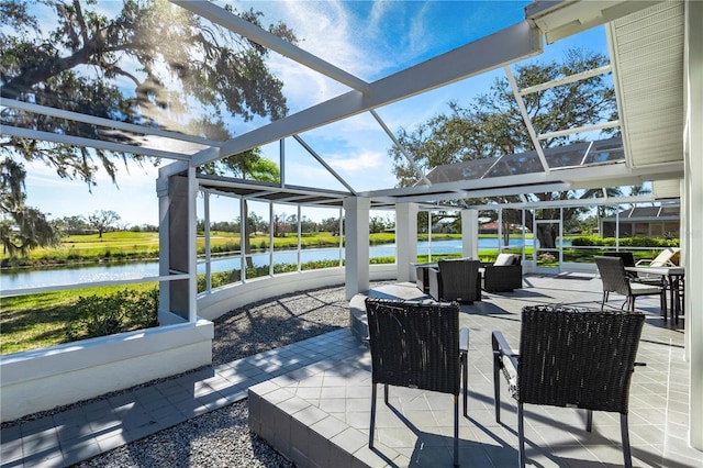 view of patio featuring a lanai and a water view