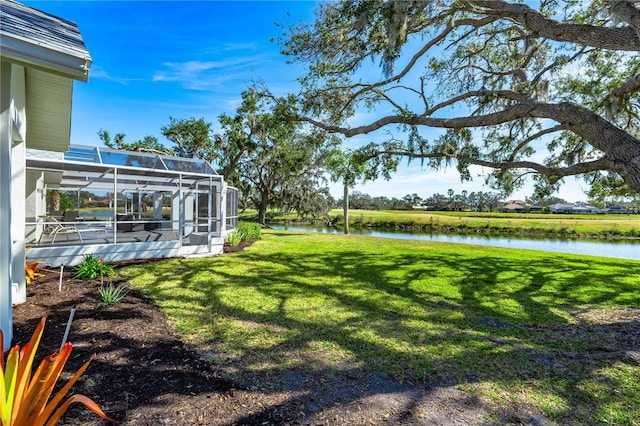 view of yard featuring a water view and glass enclosure