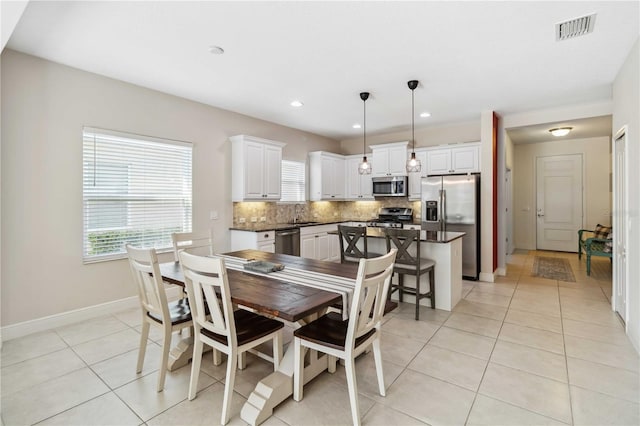 dining room featuring sink and light tile patterned floors