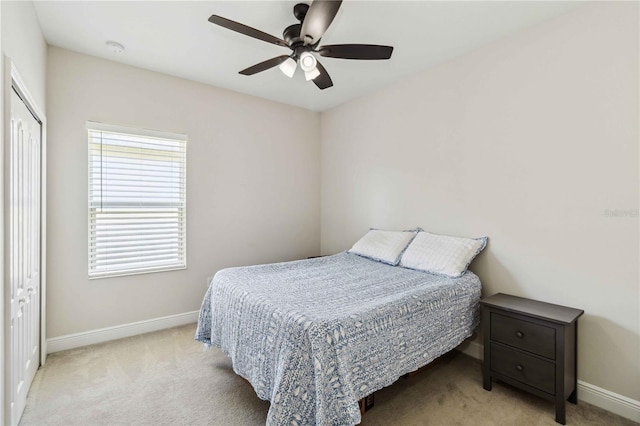 bedroom with ceiling fan, a closet, and light carpet