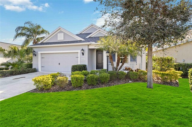 10931 Blue Magnolia Ln, Parrish, FL 34219 - view of front facade with a garage, a front yard, a porch, and driveway