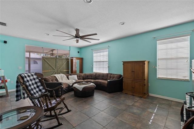 living room with ceiling fan and a textured ceiling