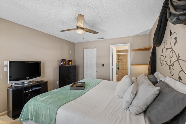 carpeted bedroom with ceiling fan, connected bathroom, and a textured ceiling