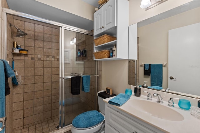 bathroom featuring vanity, toilet, and a shower with door