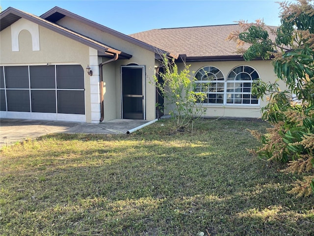 ranch-style house with a garage and a front lawn