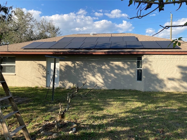 view of side of home featuring solar panels and a lawn