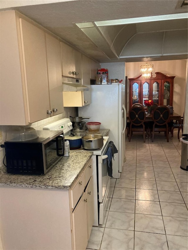 kitchen with white electric stove, light tile patterned floors, and light stone counters