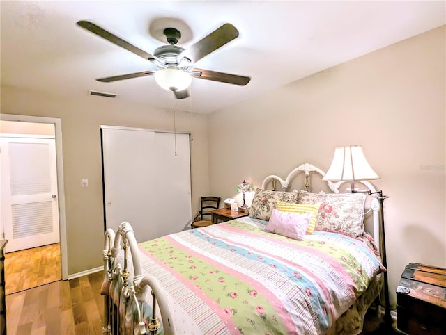 bedroom featuring hardwood / wood-style flooring, a closet, and ceiling fan