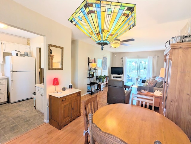 dining area featuring light wood-type flooring and a ceiling fan