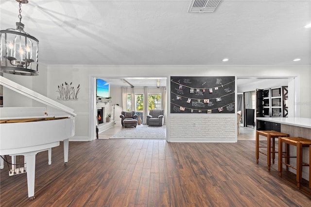 entrance foyer with crown molding, dark wood-type flooring, and an inviting chandelier