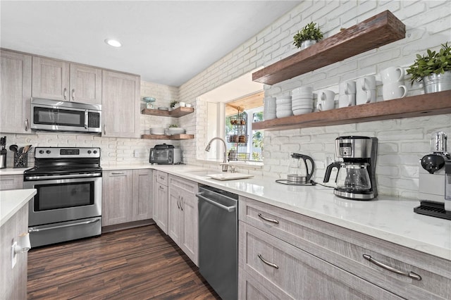 kitchen with appliances with stainless steel finishes, dark hardwood / wood-style floors, light brown cabinetry, sink, and backsplash