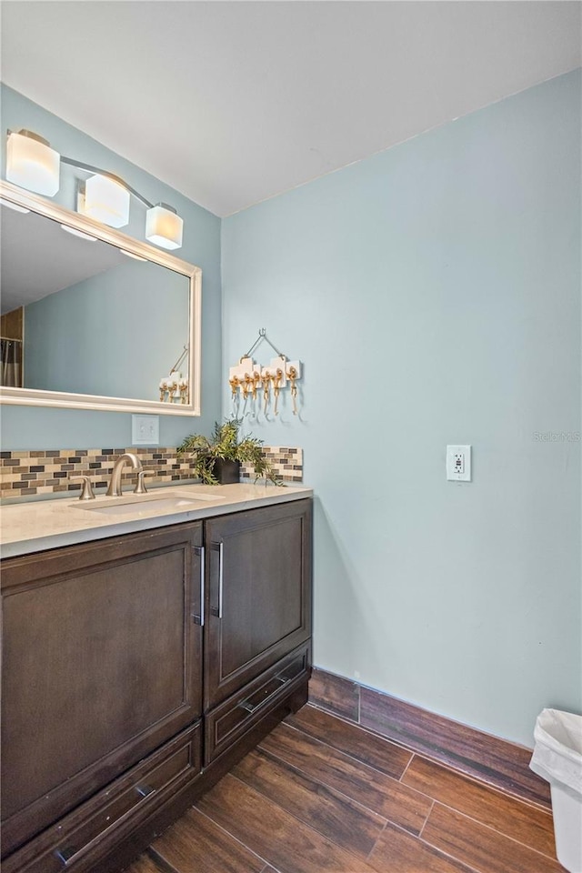 bathroom featuring vanity, hardwood / wood-style floors, and decorative backsplash