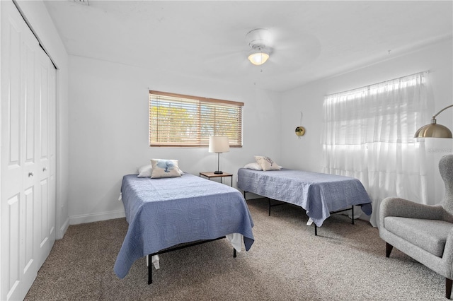 carpeted bedroom featuring ceiling fan and a closet