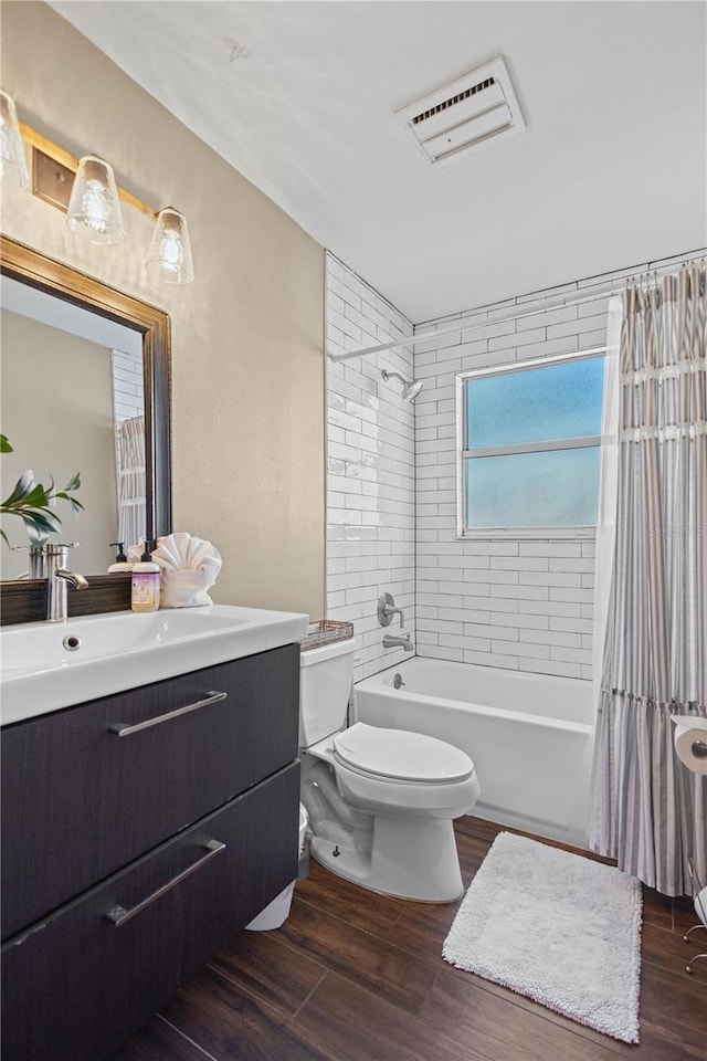 full bathroom featuring hardwood / wood-style flooring, shower / tub combo with curtain, vanity, and toilet