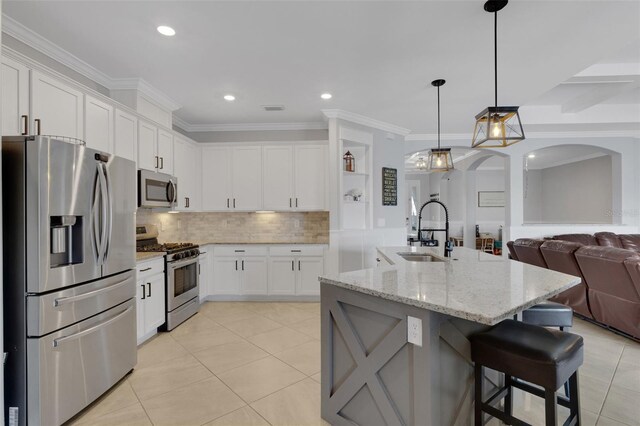 5035 Seafoam Trl, Bradenton, FL 34211 - kitchen featuring appliances with stainless steel finishes, a sink, arched walkways, light tile patterned floors, and backsplash