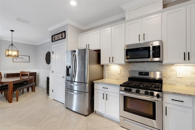 5035 Seafoam Trl, Bradenton, FL 34211 - kitchen with appliances with stainless steel finishes, crown molding, a chandelier, white cabinets, and light tile patterned floors