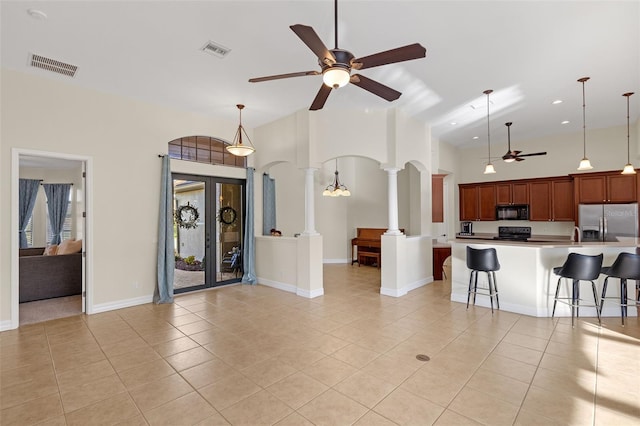 interior space with decorative columns and ceiling fan