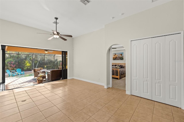 interior space featuring lofted ceiling, ceiling fan, and light tile patterned flooring