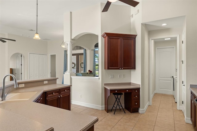 kitchen featuring sink, light tile patterned flooring, ceiling fan, and ornate columns