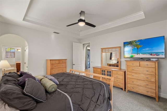 carpeted bedroom with ceiling fan, ornamental molding, and a tray ceiling