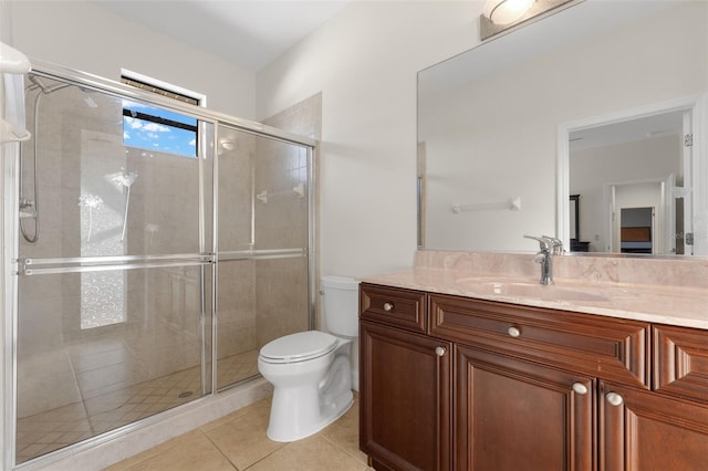 bathroom with vanity, tile patterned floors, a shower with door, and toilet