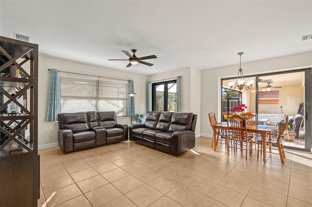 tiled living room with ceiling fan with notable chandelier