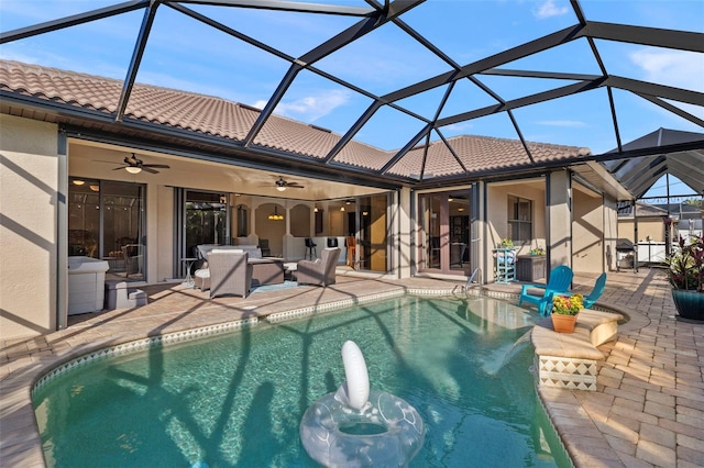 view of pool with ceiling fan, a lanai, and a patio area