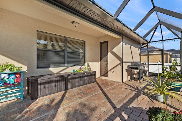 view of patio with grilling area and glass enclosure