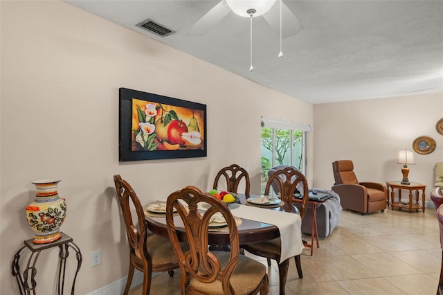 tiled dining room with ceiling fan and a textured ceiling