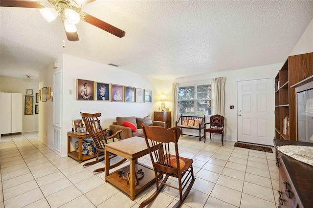 tiled dining area with ceiling fan and a textured ceiling