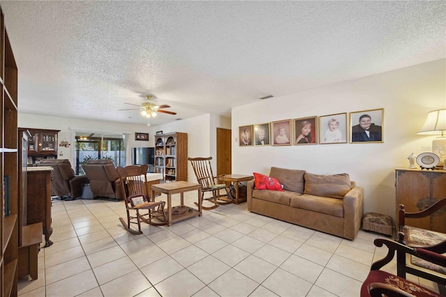 living room with light tile patterned floors, a textured ceiling, and ceiling fan