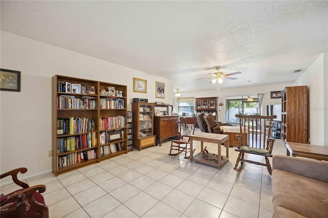 dining room with ceiling fan, a textured ceiling, and light tile patterned floors