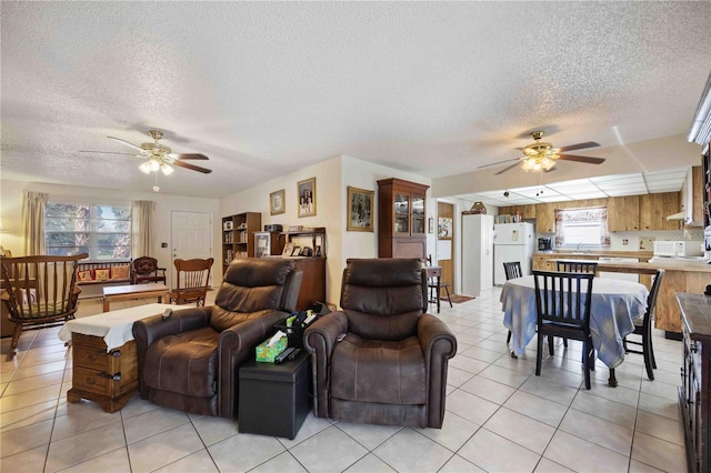 living room with light tile patterned floors, a textured ceiling, and ceiling fan