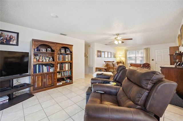 living room featuring light tile patterned floors, a textured ceiling, and ceiling fan