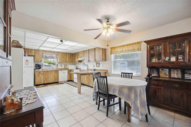 kitchen with white appliances, plenty of natural light, ceiling fan, and light tile patterned flooring