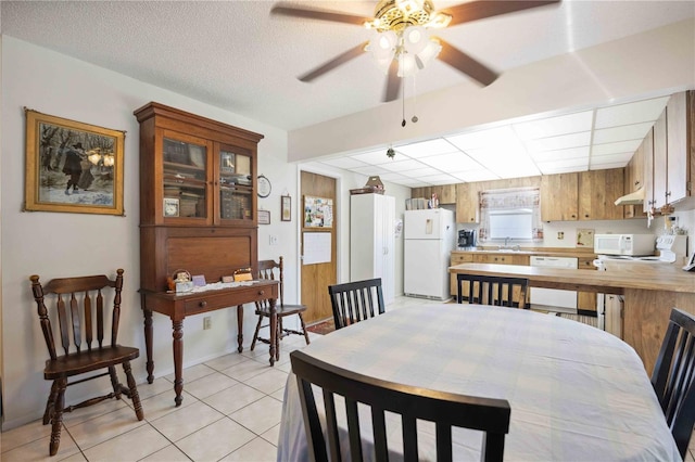 dining area with light tile patterned floors, a textured ceiling, and ceiling fan