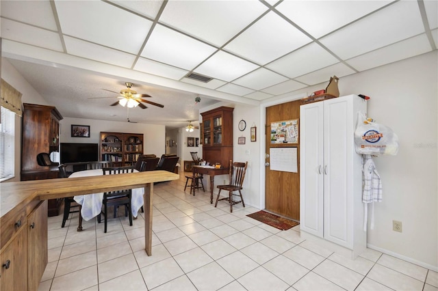 kitchen with light tile patterned floors, a paneled ceiling, and ceiling fan