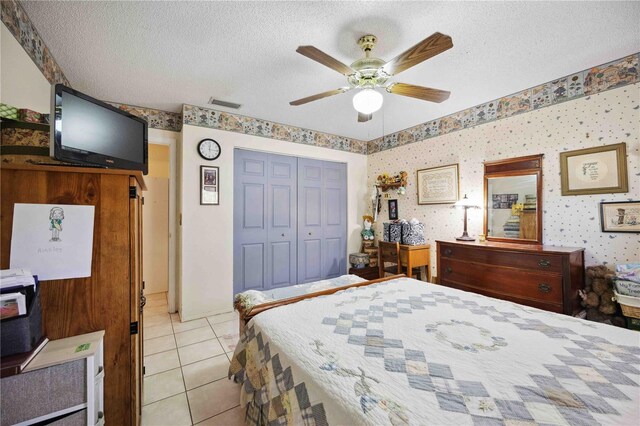 tiled bedroom featuring ceiling fan, a closet, and a textured ceiling